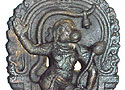 Sri Anjaneya wears a lock of hair, a belled tail, and a lotus flower in his hand